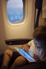 Image showing Boy spending time with tablet PC during flight