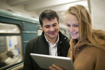 Image showing Happy young people with touch pad in subway