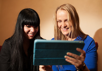 Image showing Two young woman reading a tablet-pc