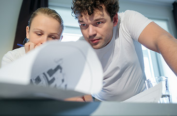 Image showing Two young architecs working with blueprints