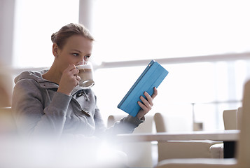 Image showing Woman in cafe using her touchpad