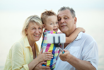 Image showing Grandparents and grandson making phone selfie