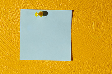 Image showing Pink sticker on the yellow wall.