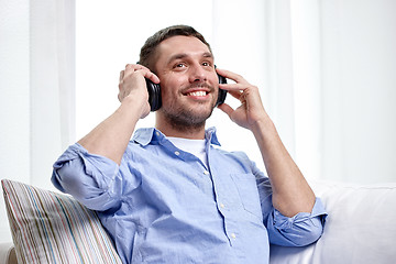 Image showing smiling young man in headphones at home