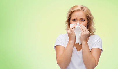 Image showing unhappy woman with paper napkin blowing nose