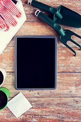 Image showing close up of tablet pc and garden tools on table