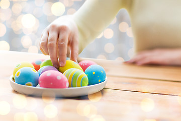 Image showing close up of woman hands with colored easter eggs