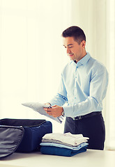 Image showing businessman packing clothes into travel bag