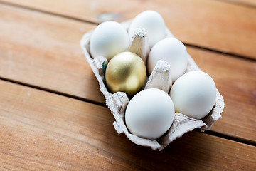 Image showing close up of white and gold eggs in egg box