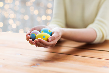 Image showing close up of woman hands with colored easter eggs