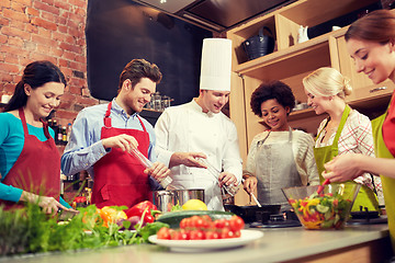 Image showing happy friends and chef cook cooking in kitchen