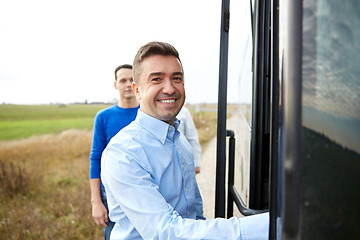 Image showing group of happy male passengers boarding travel bus