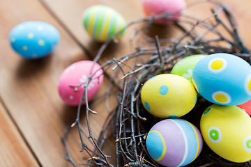 Image showing close up of colored easter eggs in nest on wood