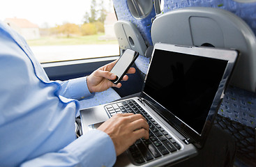 Image showing man with smartphone and laptop in travel bus