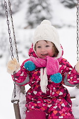 Image showing little girl at snowy winter day swing in park