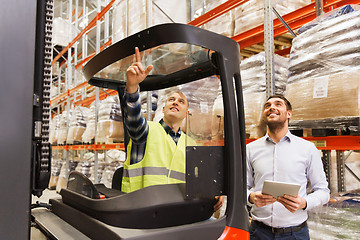 Image showing men with tablet pc and forklift at warehouse