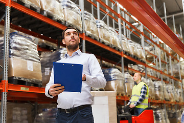 Image showing businessman with clipboard at warehouse