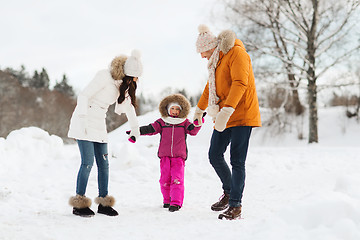 Image showing happy family in winter clothes walking outdoors