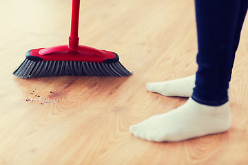 Image showing close up of woman legs with broom sweeping floor