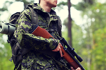 Image showing close up of soldier or hunter with gun in forest