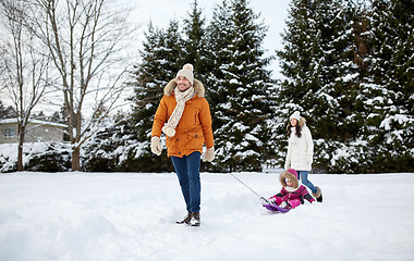 Image showing happy family with sled walking in winter outdoors