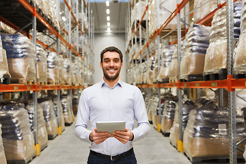 Image showing happy businessman with tablet pc at warehouse