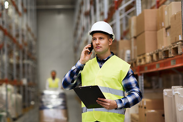 Image showing man with clipboard and smartphone at warehouse