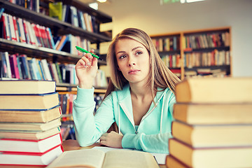 Image showing bored student or young woman with books in library
