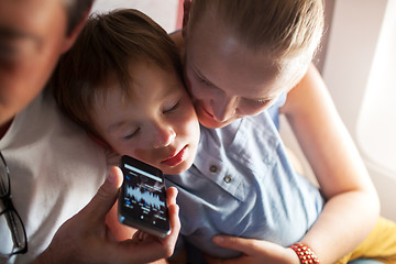 Image showing Child sleeping with music on cell phone in plane