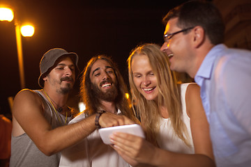 Image showing Young friends laughing at what they see on mobile