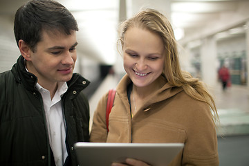 Image showing Young couple using tablet computer in underground