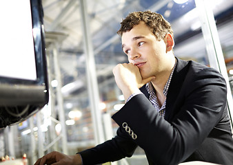 Image showing Smart young man is working on the computer.