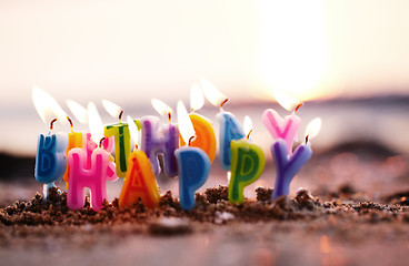 Image showing Birthday candles burning on a seashore