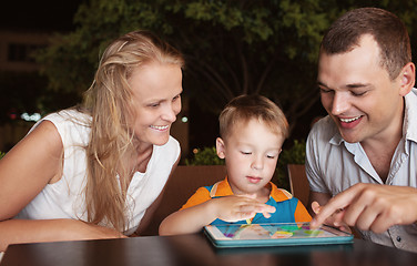 Image showing Family of three spending time in cafe with tablet computer