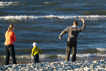 Image showing Family of three on pebble beach