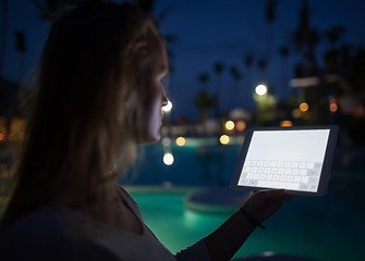 Image showing Woman tourist with pad on tropical resort in late evening