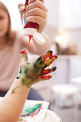 Image showing Young child playing with finger paints