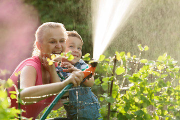 Image showing Mother and son playing with water