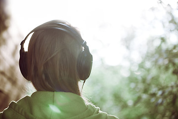 Image showing Woman in headphones against bright sunlight