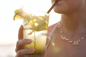Image showing Woman enjoying a tropical mojito cocktail