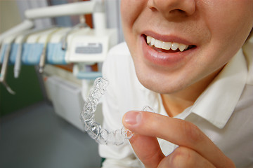 Image showing Smiling man holding silicone mouth guard