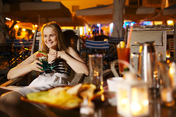 Image showing Smiling woman drinking in a cafeteria