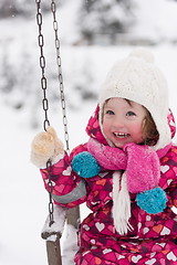 Image showing little girl at snowy winter day swing in park