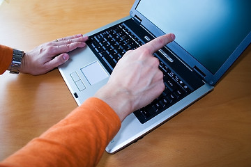 Image showing Young pointing to laptop