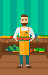 Image showing Supermarket worker with box full of apples.