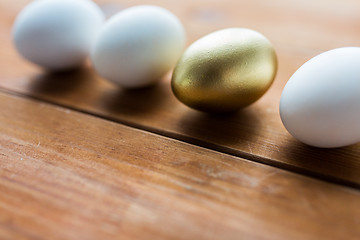 Image showing close up of golden and white easter eggs on wood