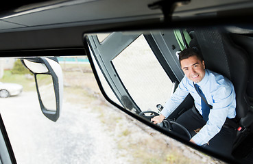 Image showing close up of driver reflection in bus mirror