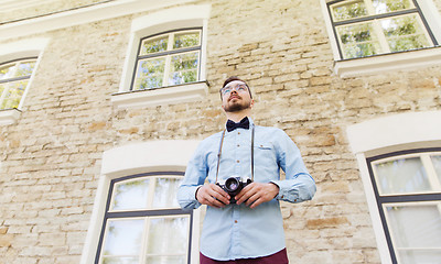 Image showing happy young hipster man with film camera in city