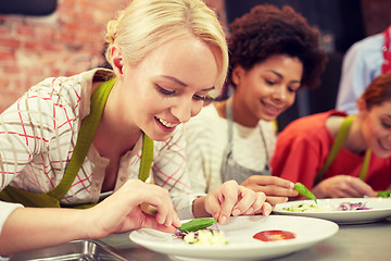 Image showing happy women cooking and decorating dishes