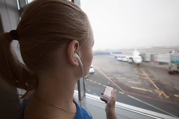 Image showing Woman in headphones looking at aiport area